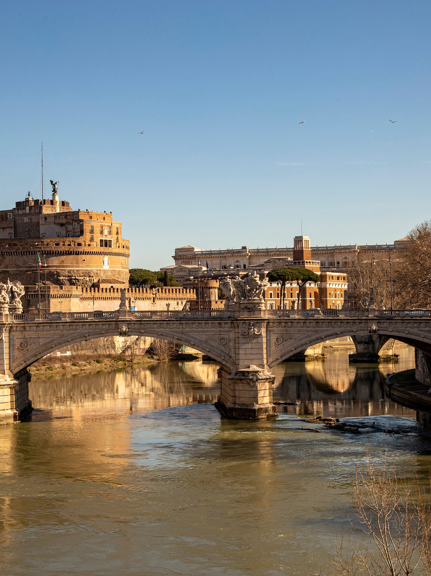 a bridge over a river with a castle in the background