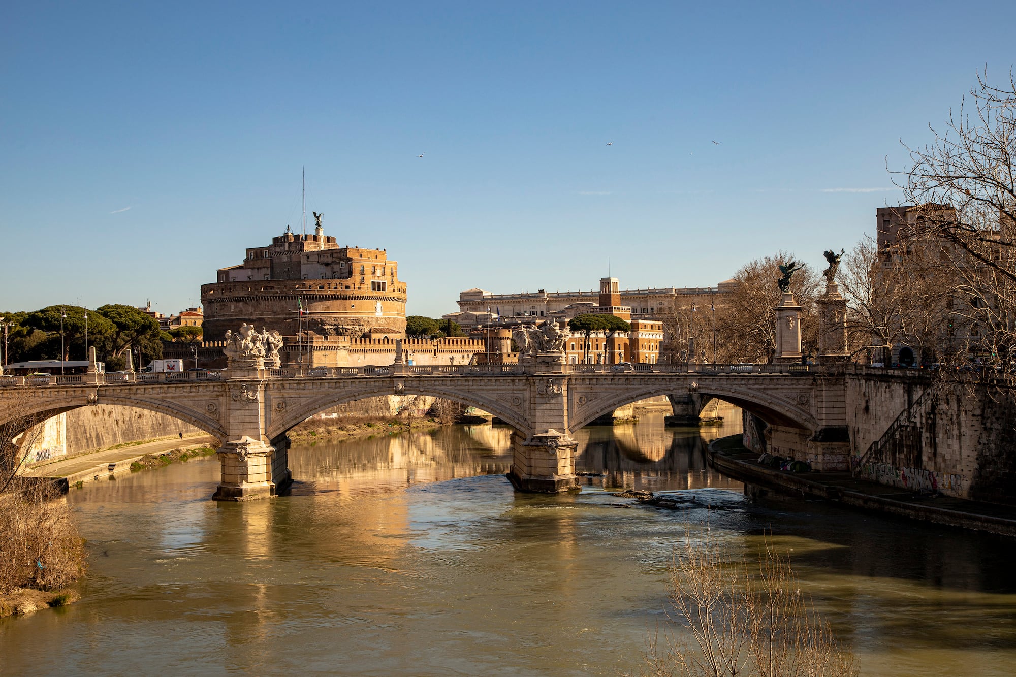 a bridge over a river with a castle in the background