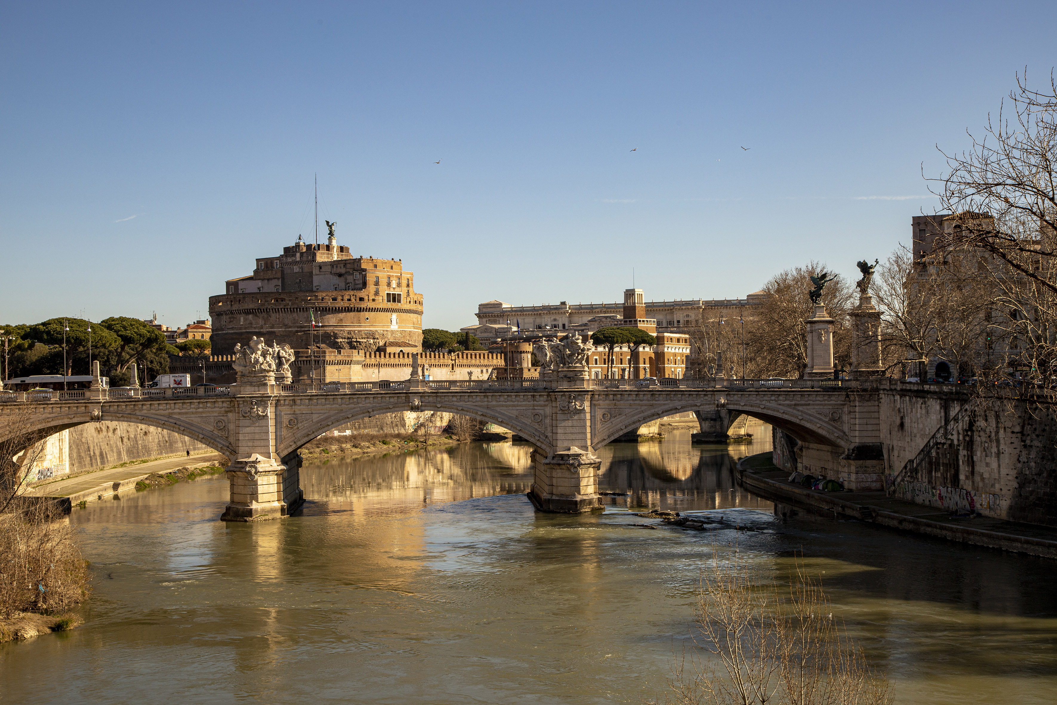 a bridge over a river with a castle in the background