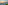 Coastal sunset over ocean with lounge chairs, cocktails, and beach fence.