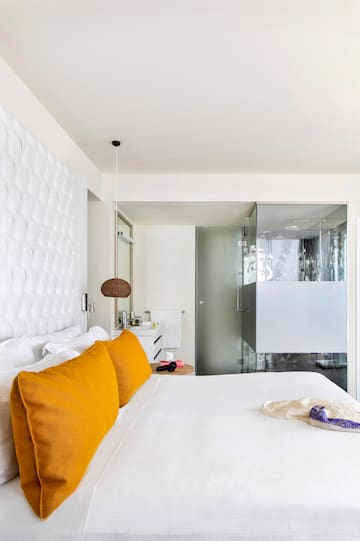 a bed with a lamp and a glass door