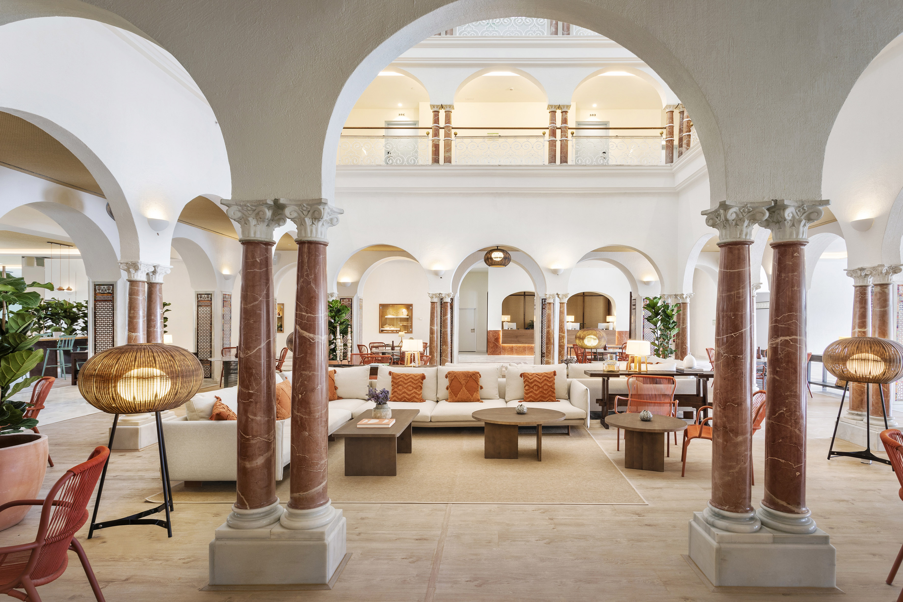 Luxurious hotel lounge with grand arches, marble columns, and comfortable sofas.
