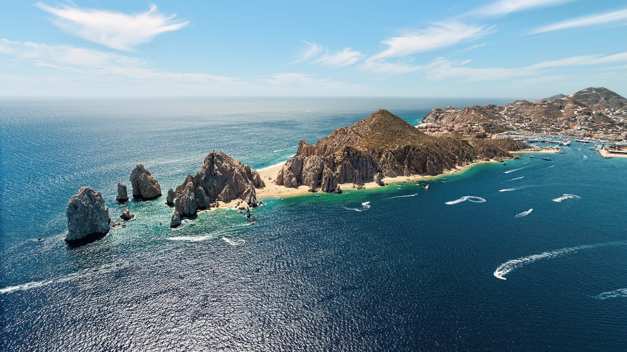 a large body of water with rocks and land in the distance