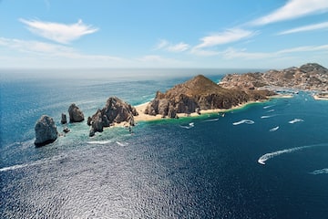 a large body of water with rocks and land in the distance