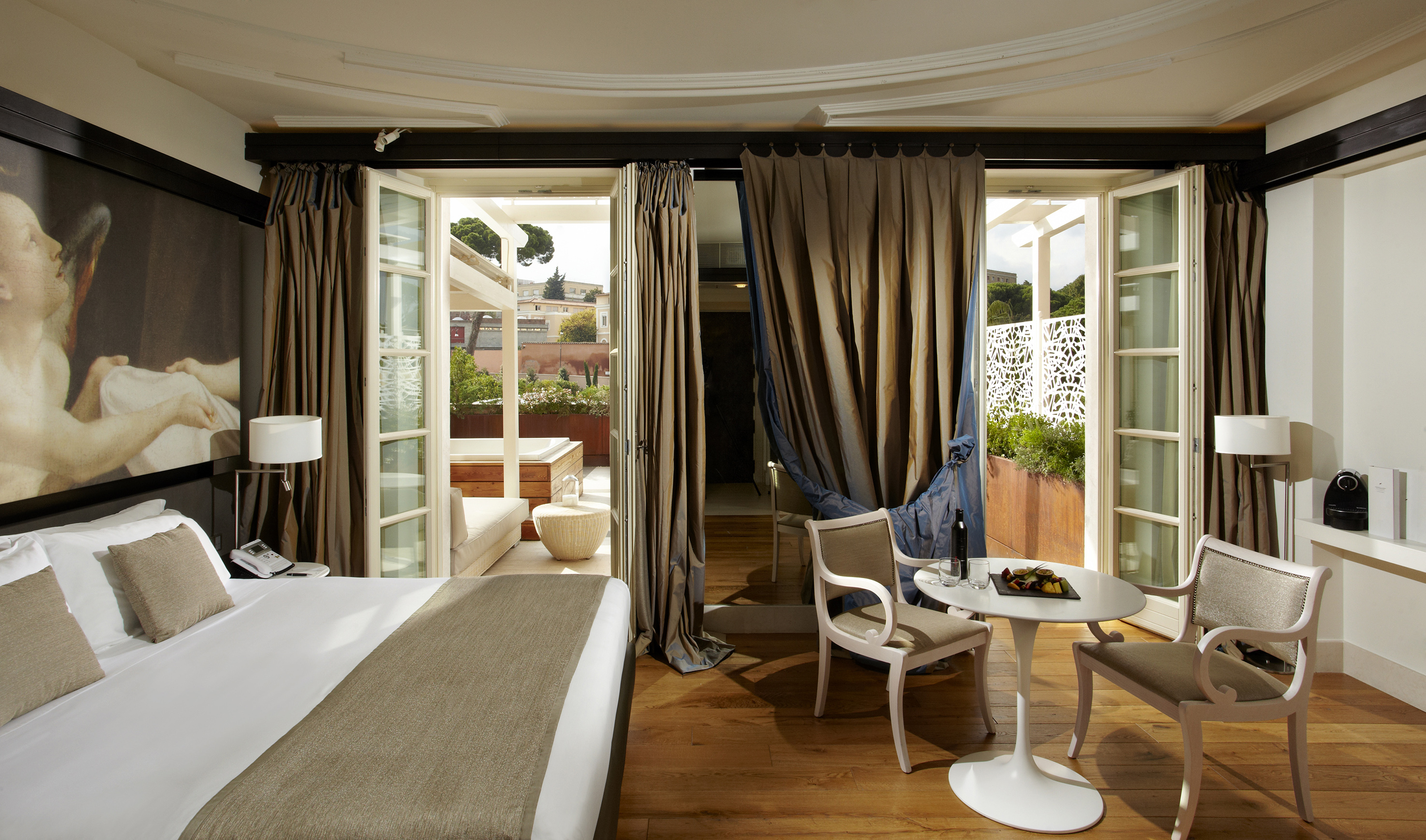 Luxury hotel room with private terrace, hot tub, and elegant decor.