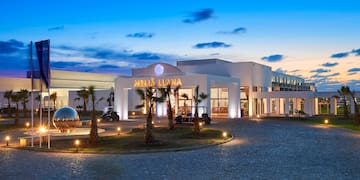 a building with palm trees and a round driveway