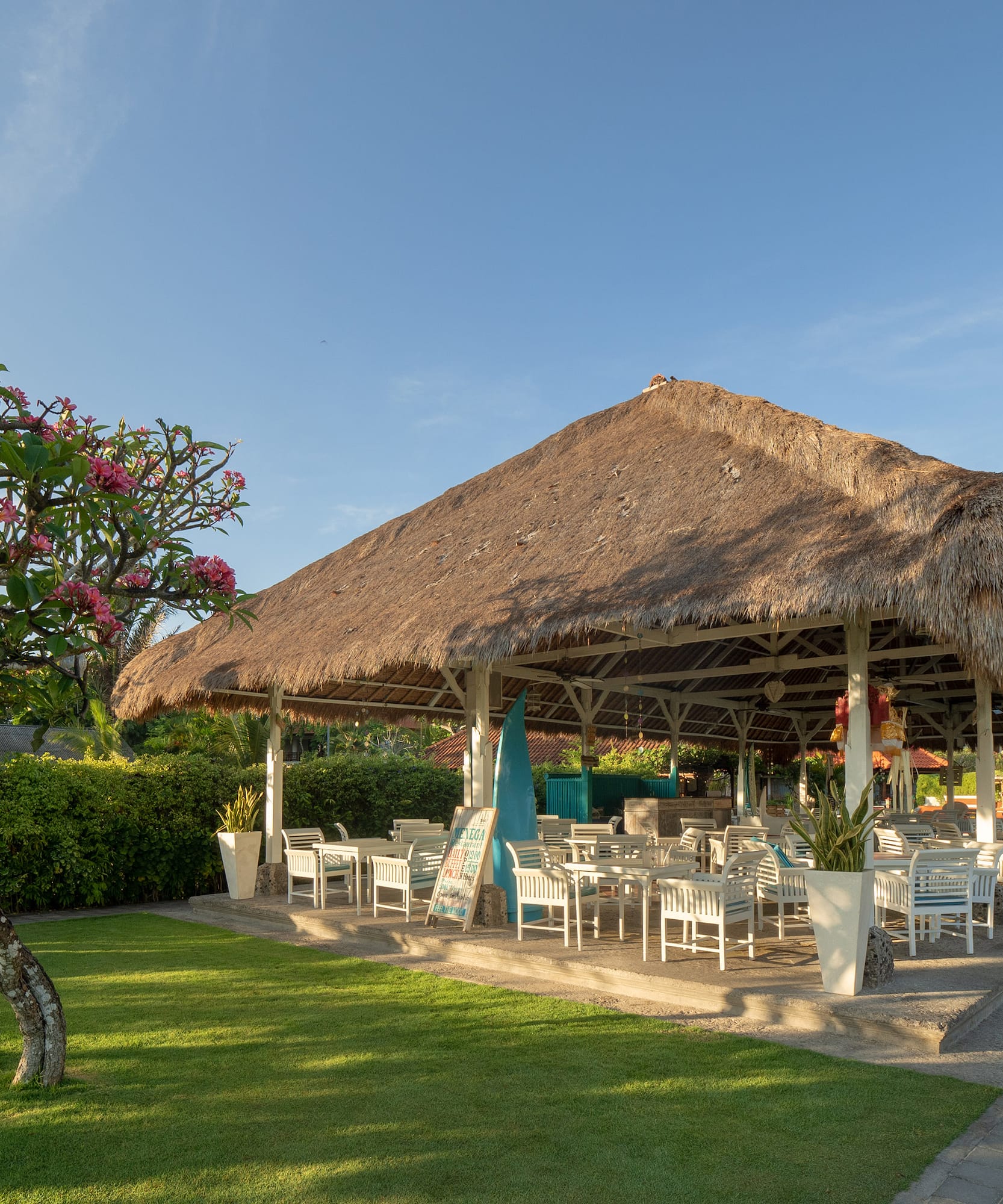 a grass covered gazebo with tables and chairs