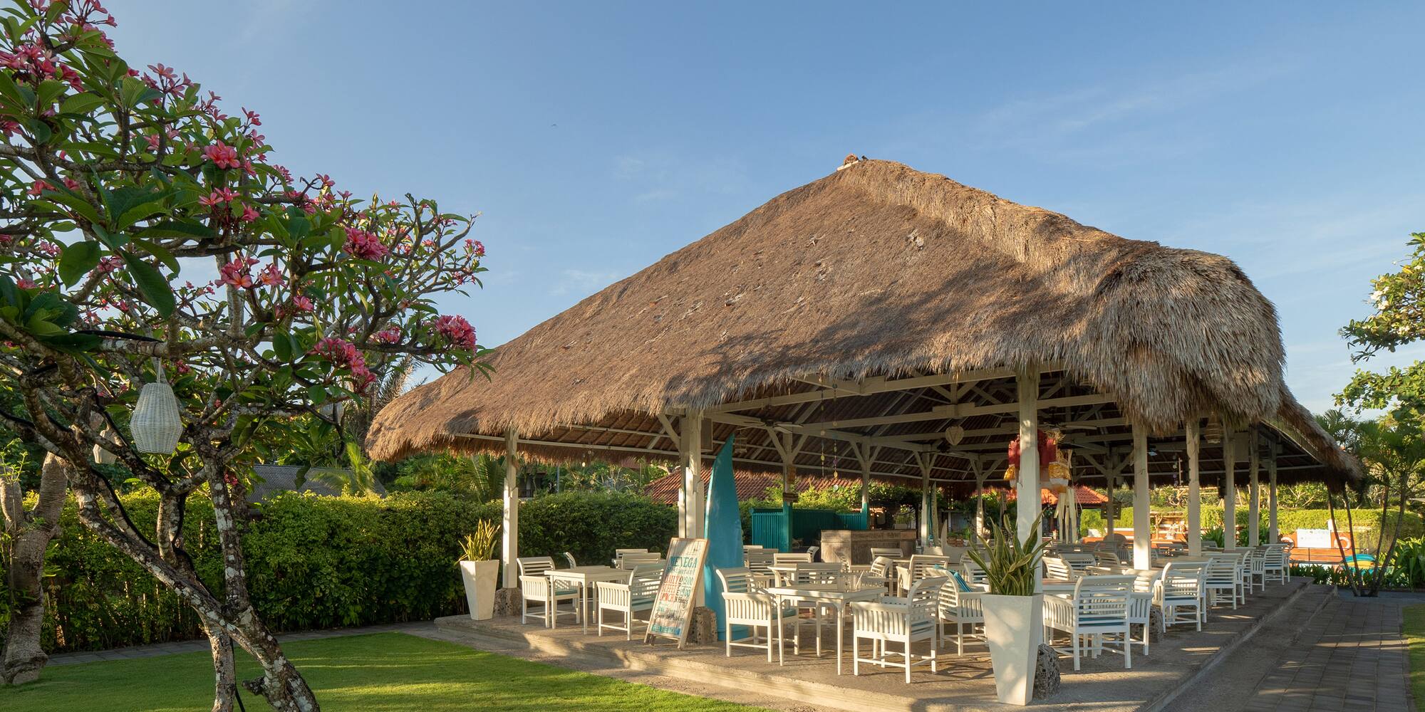 a grass covered gazebo with tables and chairs