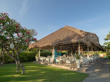 a grass covered gazebo with tables and chairs
