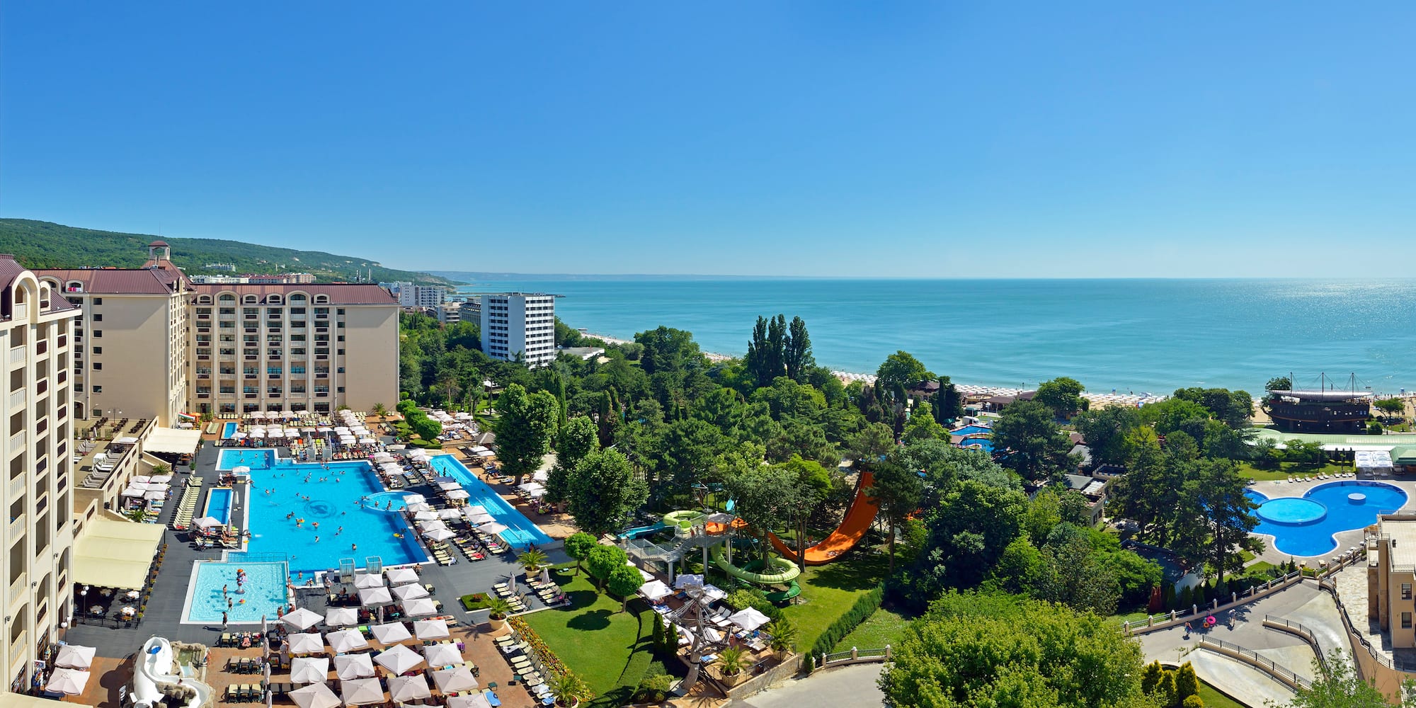a swimming pool and trees by a beach