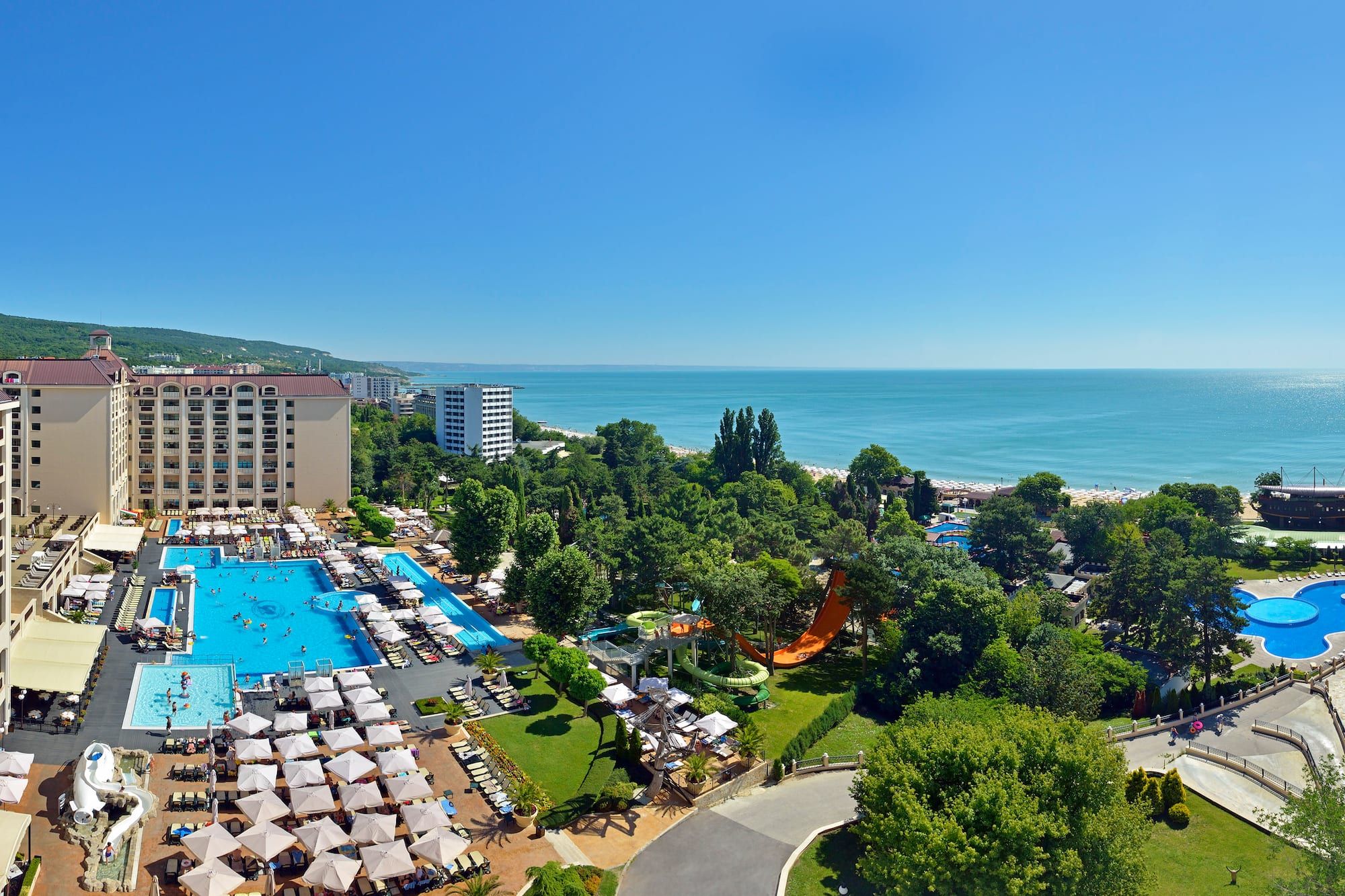 a swimming pool and trees by a beach
