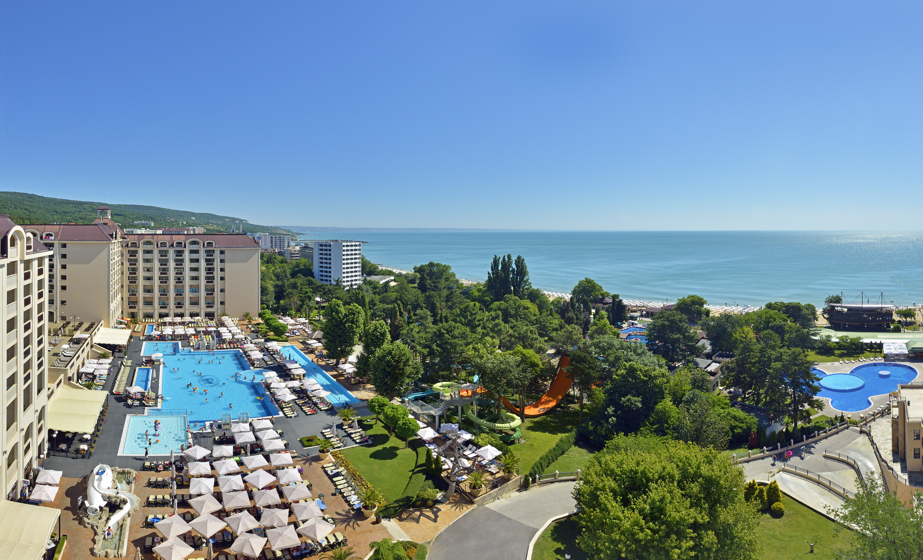 a swimming pool and trees by a beach