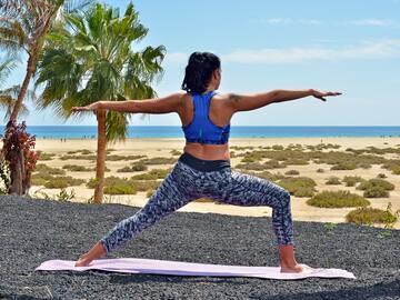a woman doing yoga on a beach