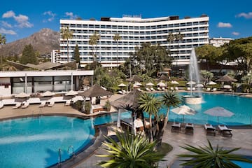 a pool with a fountain in front of a large building