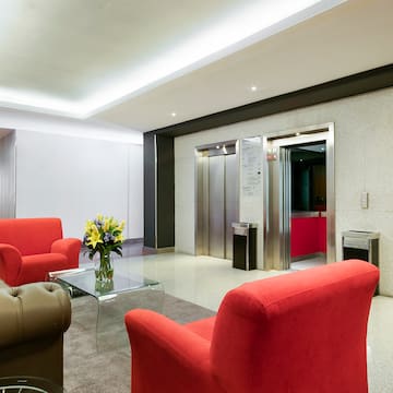 a lobby with red chairs and a glass coffee table