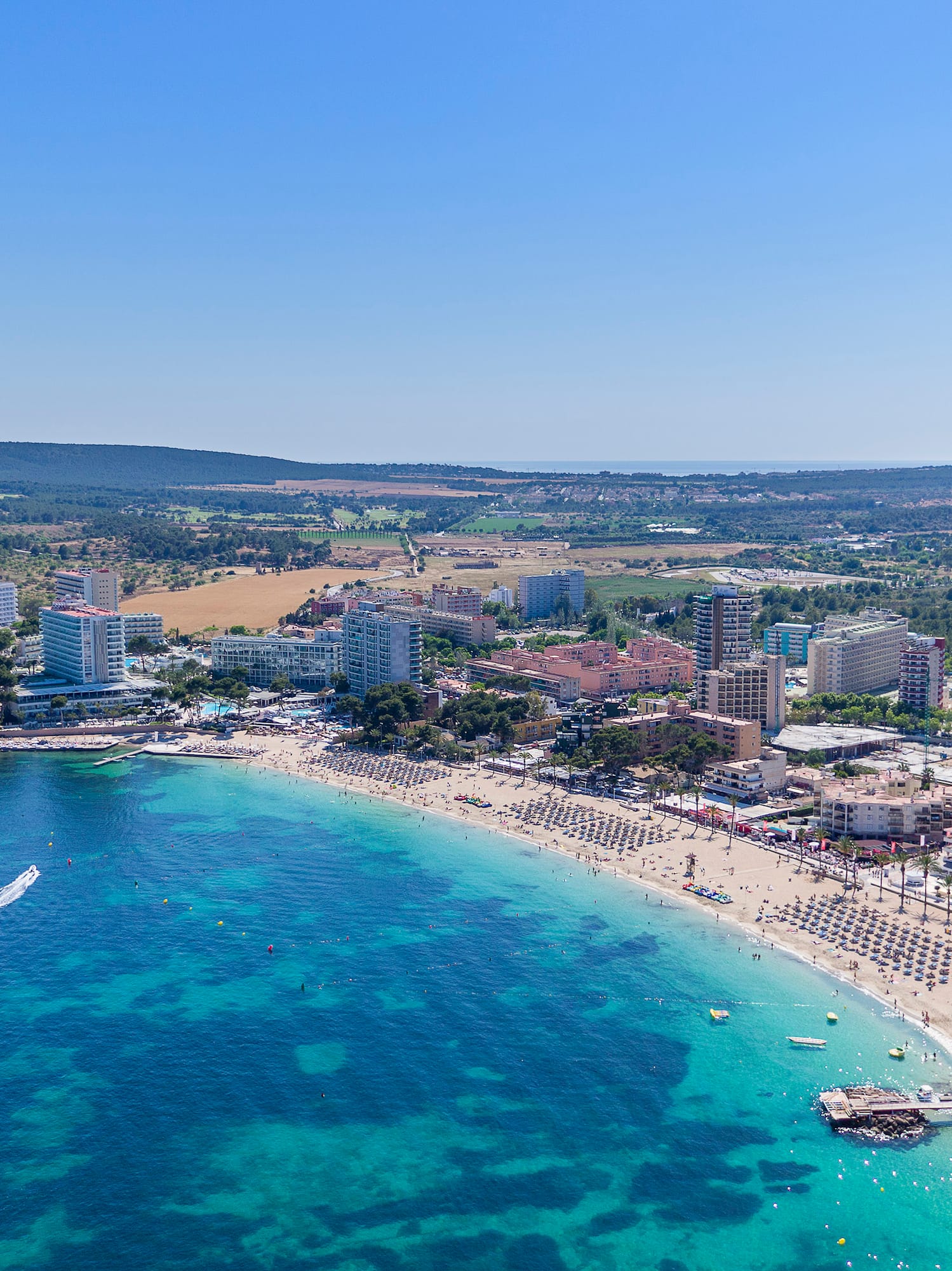 a beach with boats and buildings