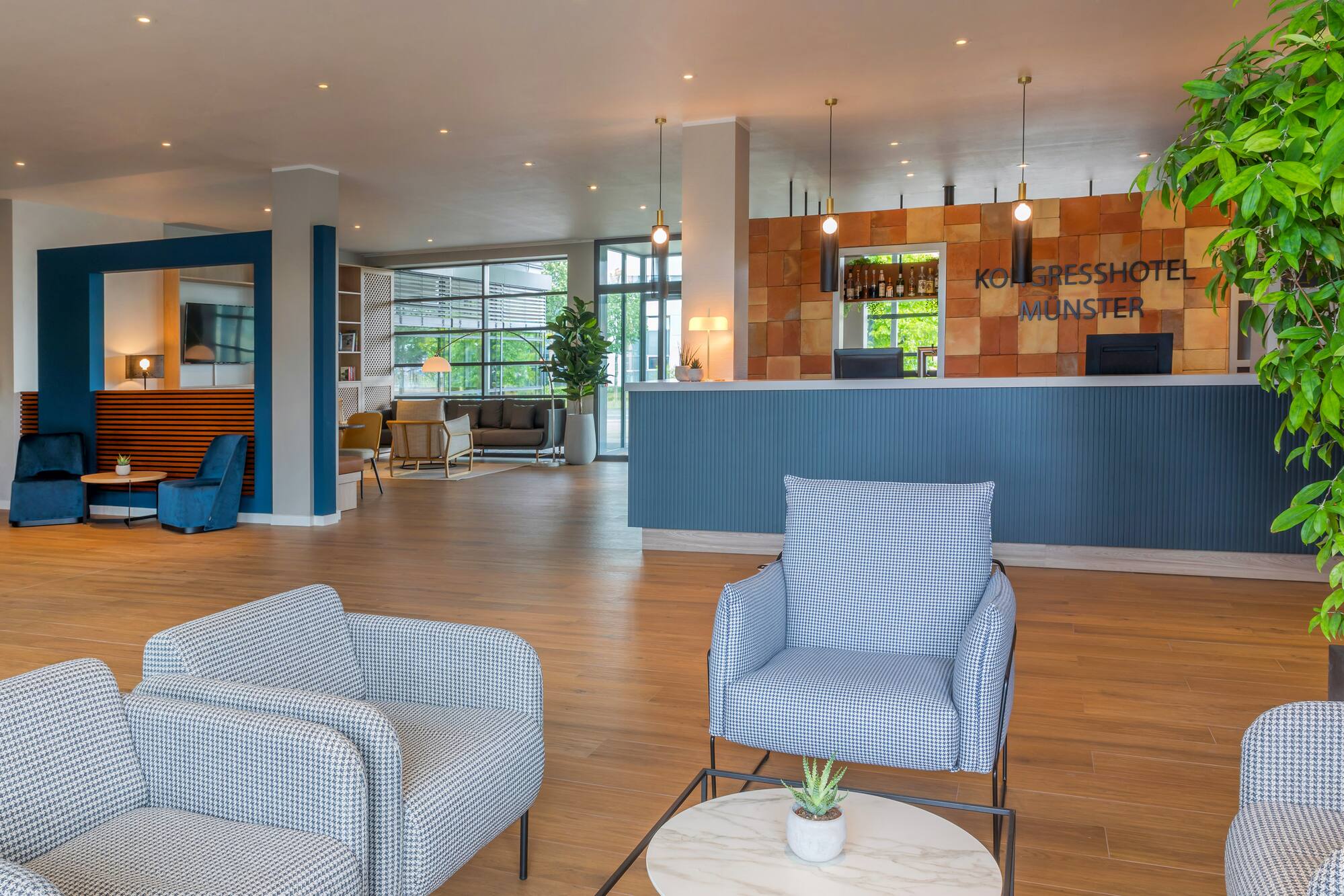 Kongresshotel Münster lobby: modern reception, stylish chairs, wood flooring.