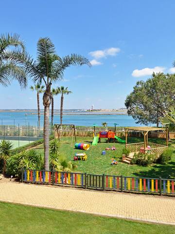 a playground with a beach and water in the background