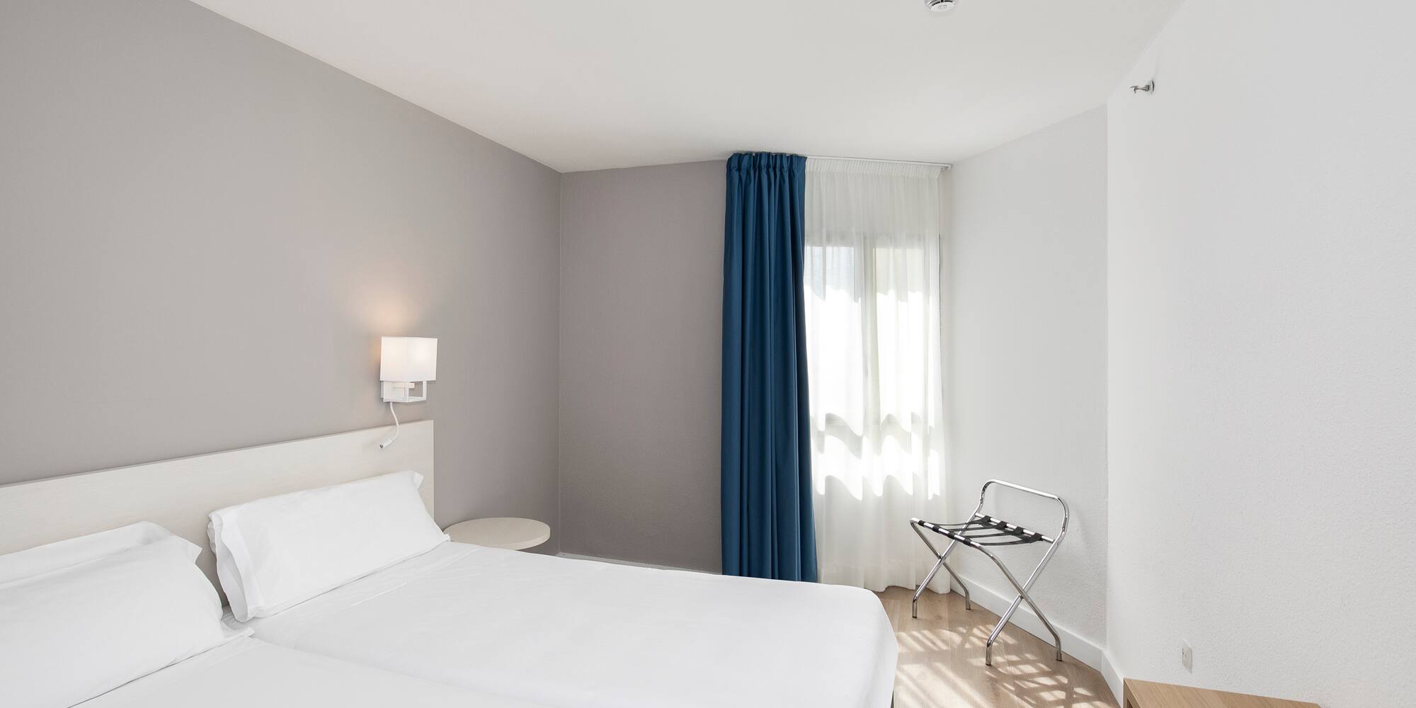 a room with two beds and a lamp