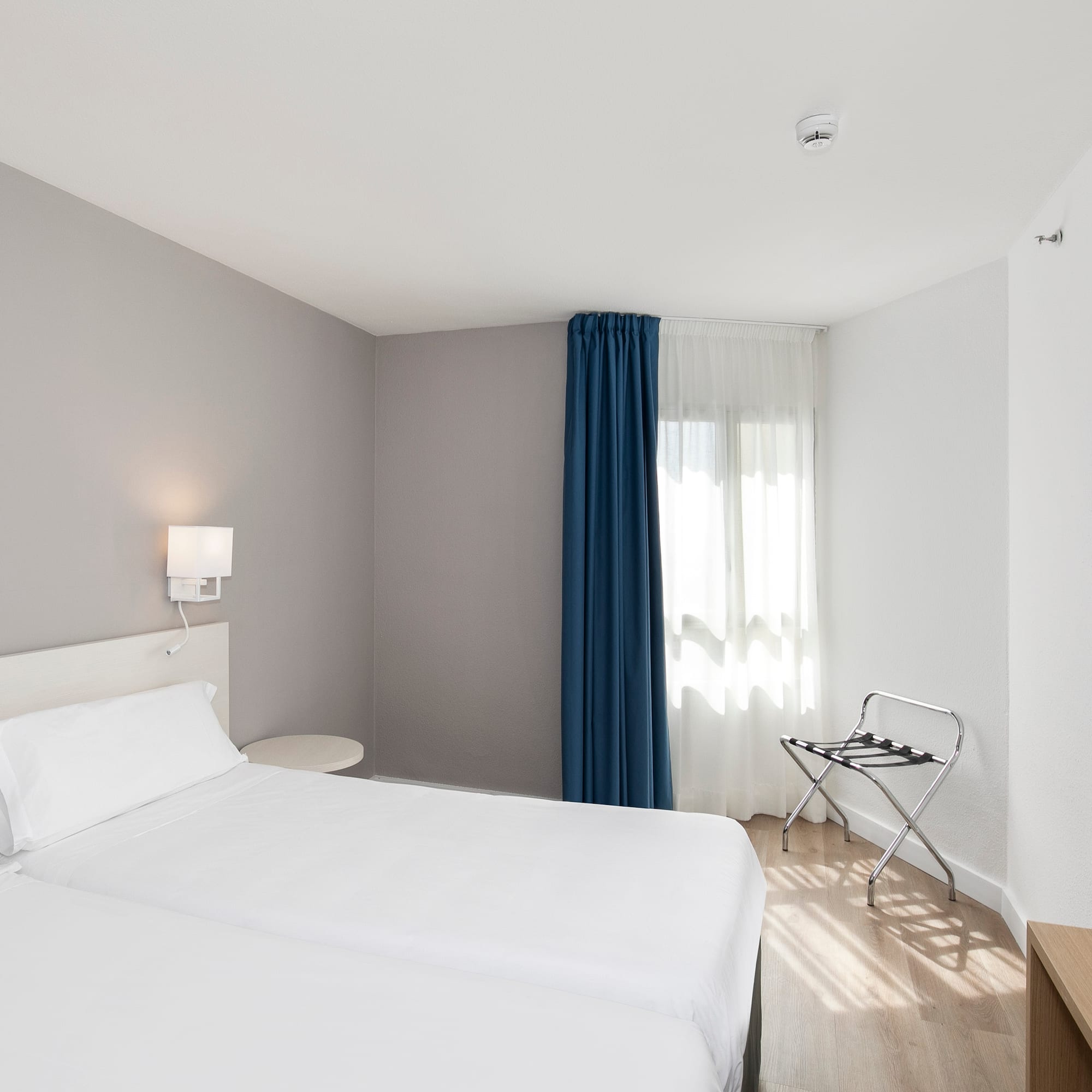 a room with two beds and a lamp