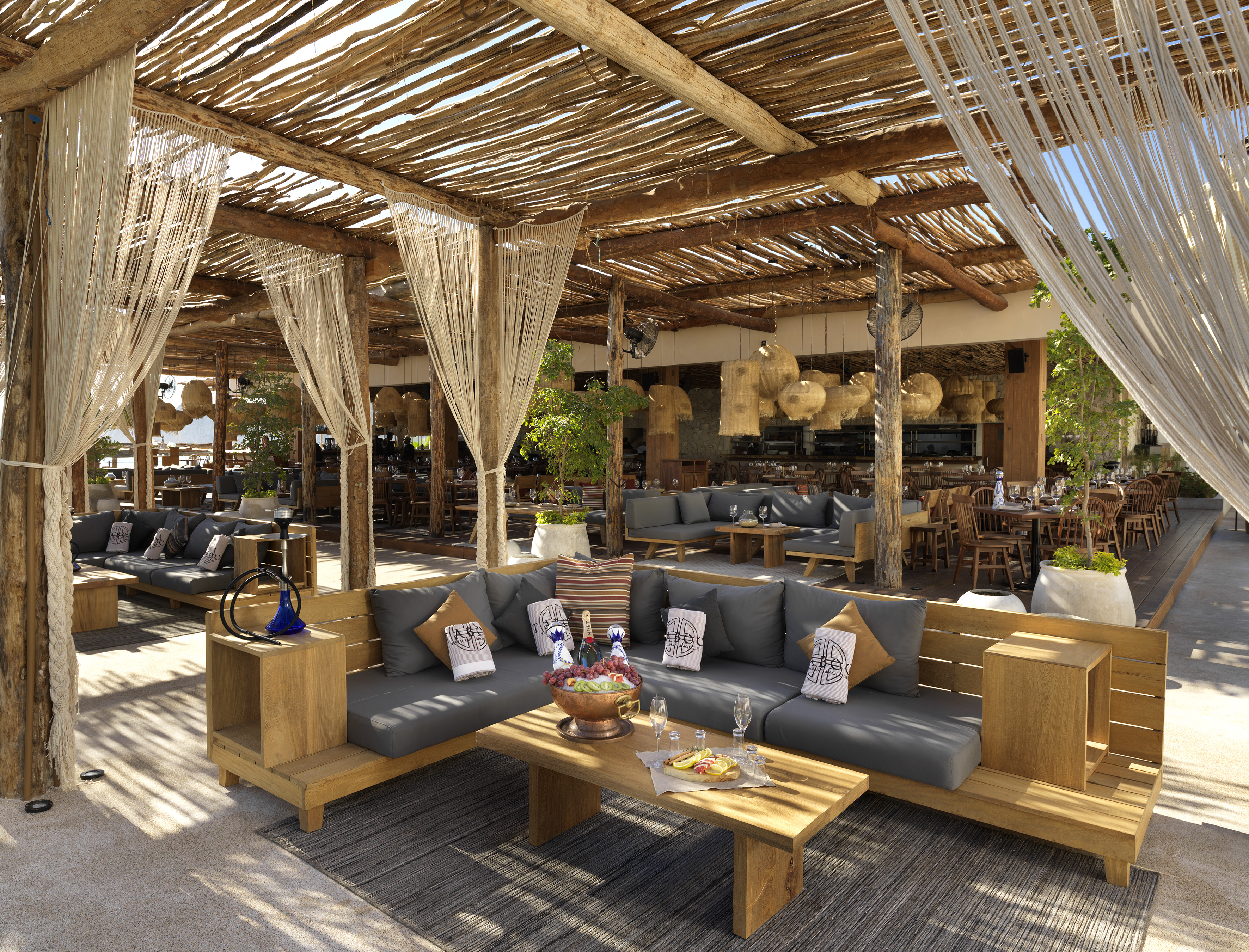 Tropical resort lounge with rustic wooden furniture and natural roof.