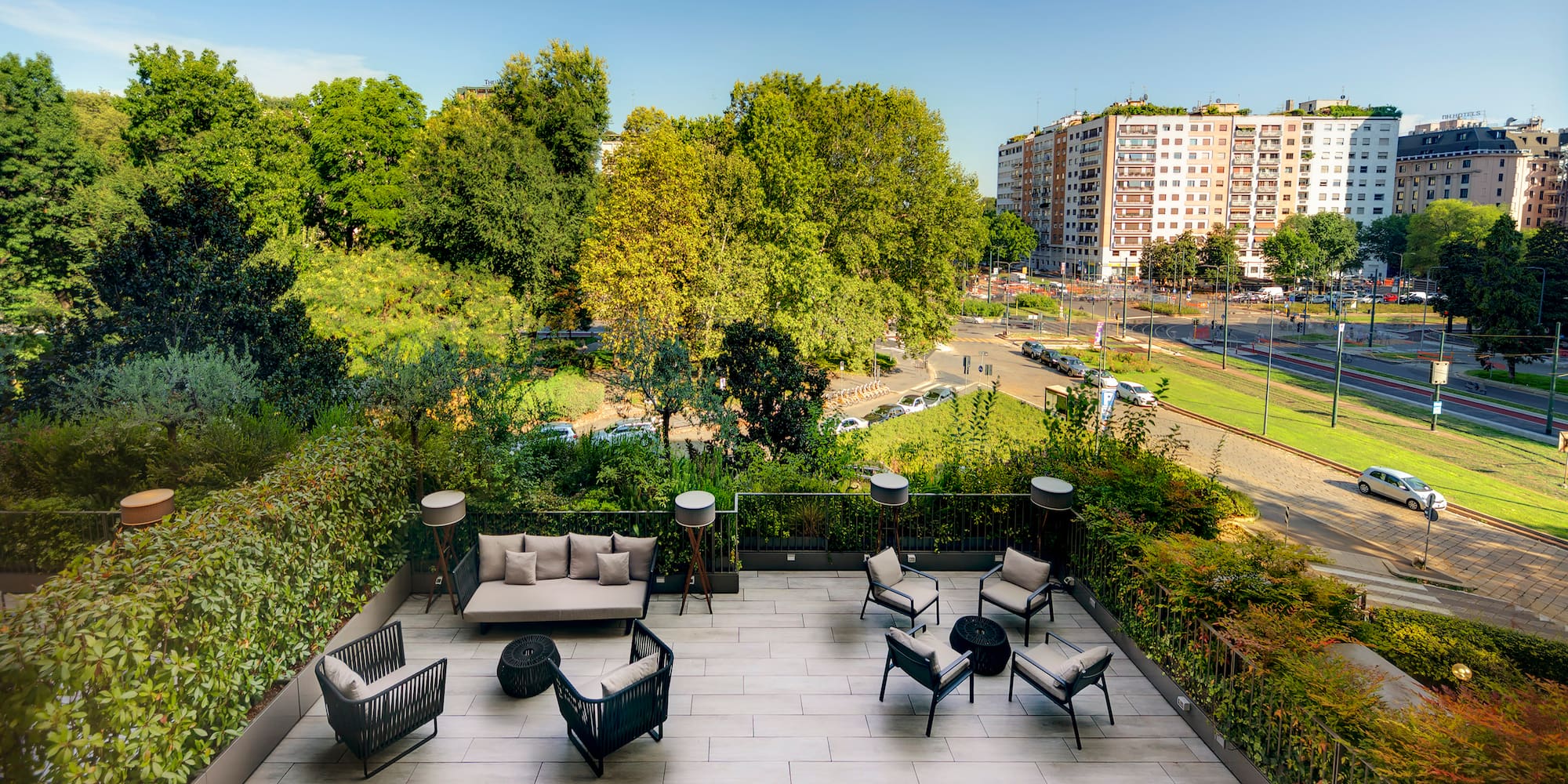 a rooftop patio with a view of a city and trees