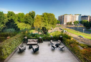a rooftop patio with a view of a city and trees