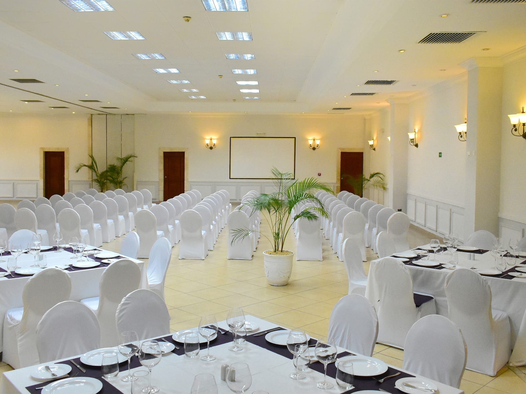 a room with white chairs and tables