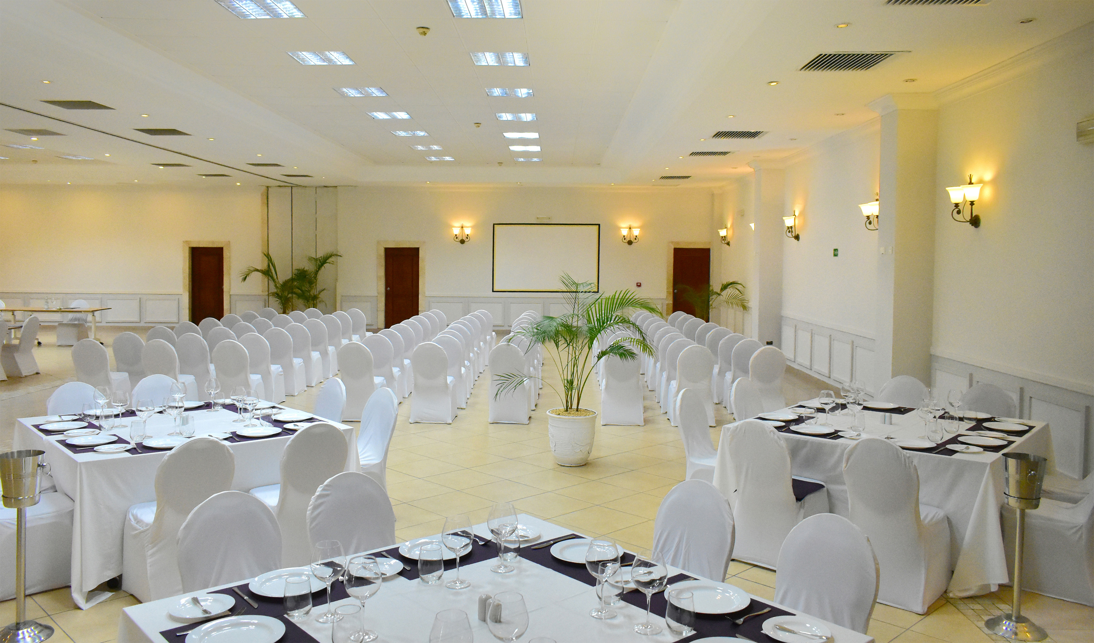 a room with white chairs and tables