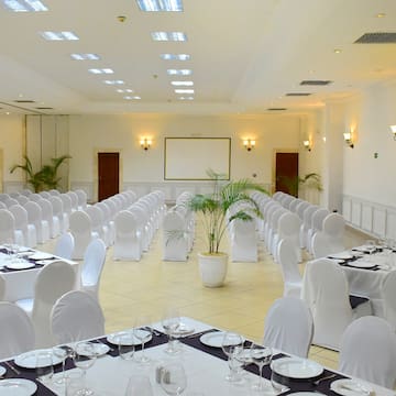 a room with white chairs and tables