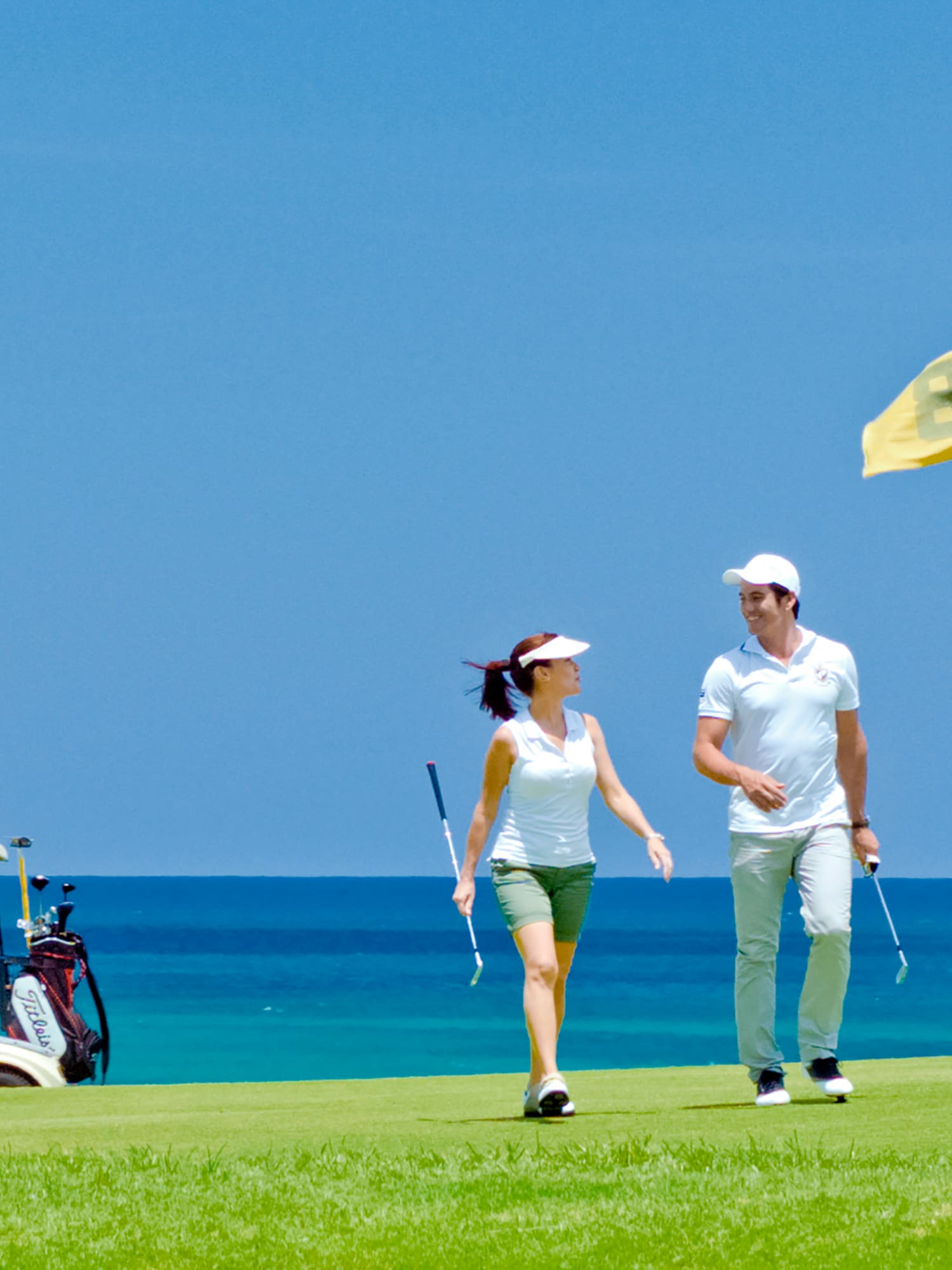 a man and woman walking on a golf course