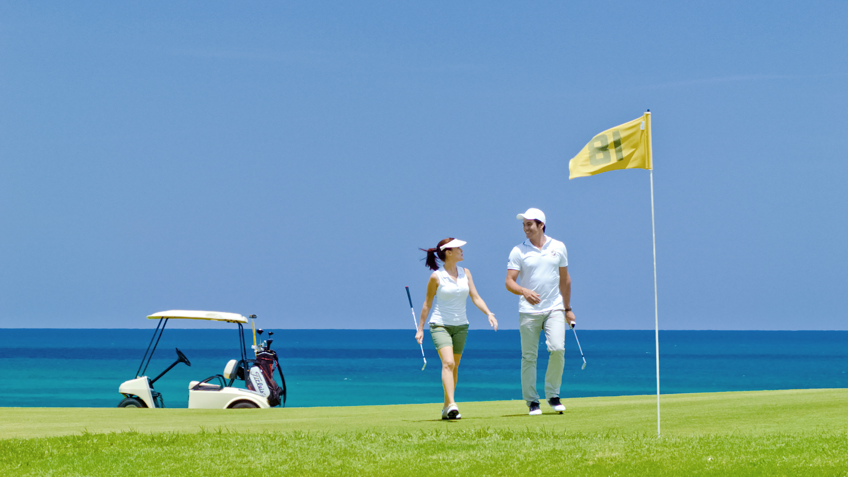a man and woman walking on a golf course
