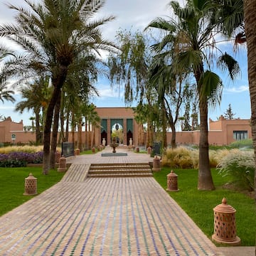 a walkway with palm trees and a building