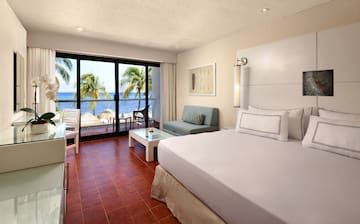 a room with a bed and a couch and chairs