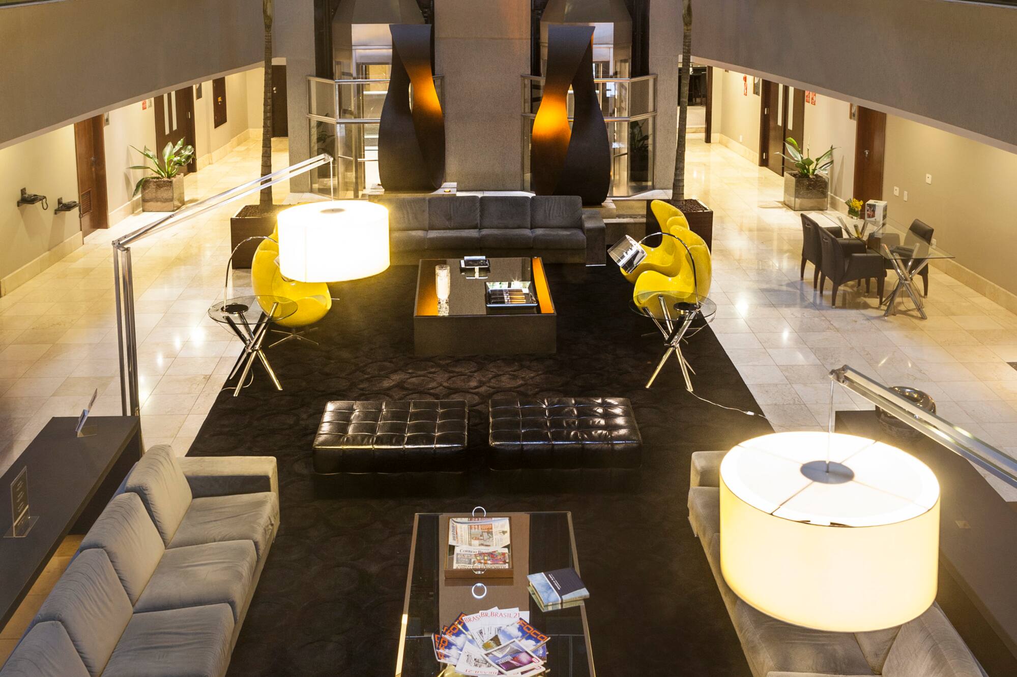 a room with a large black table and yellow chairs