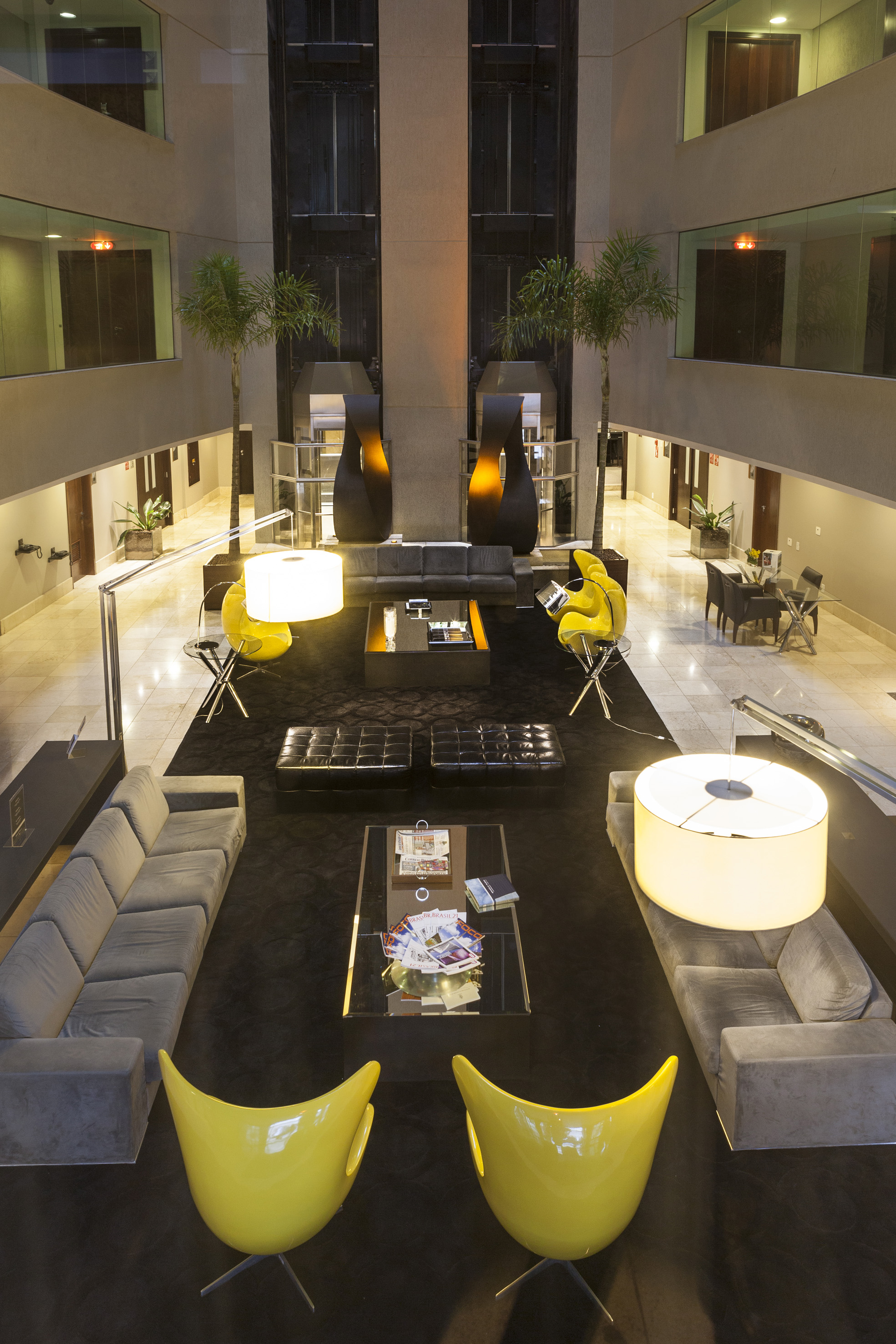 a room with a large black table and yellow chairs