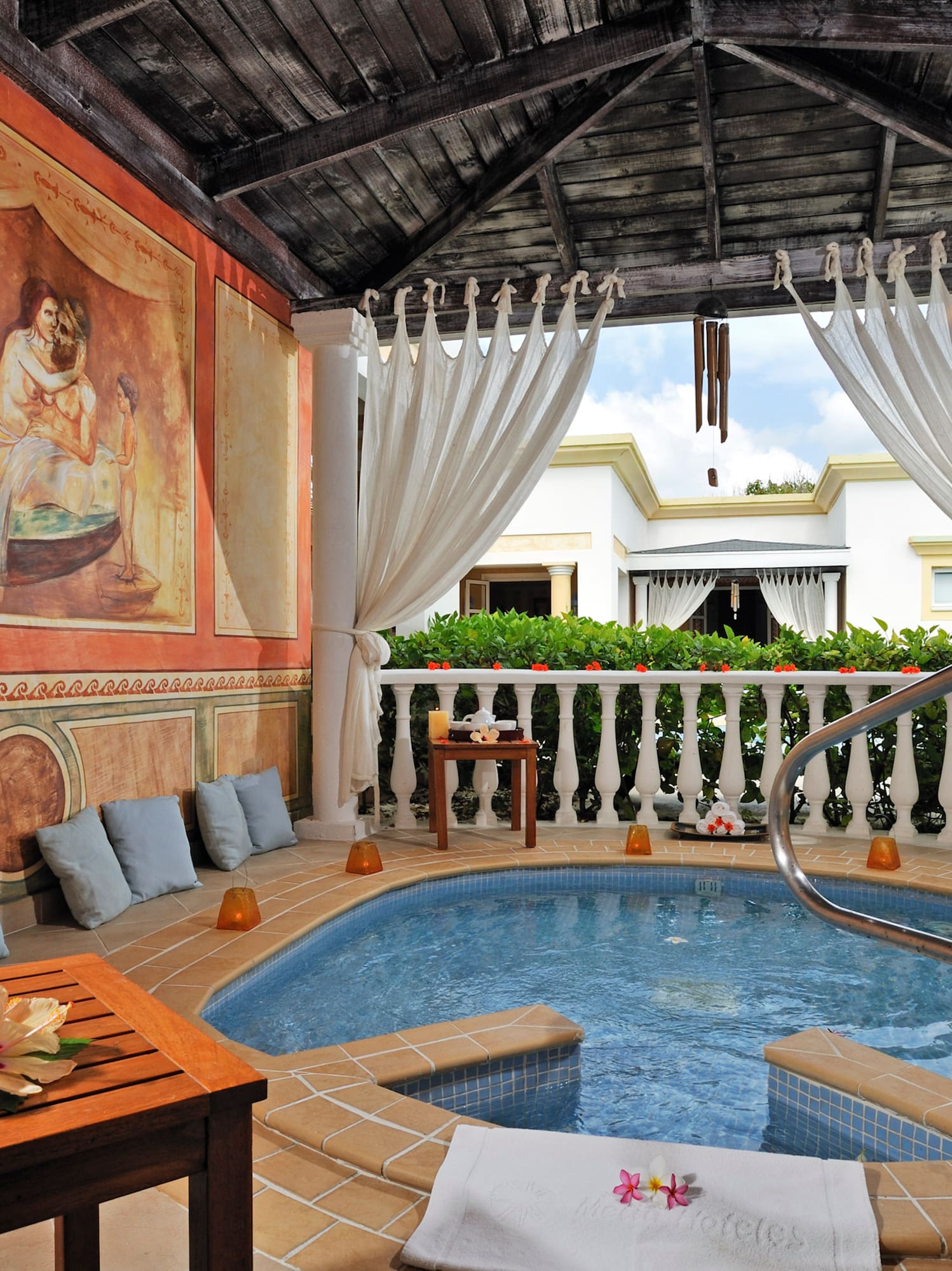 a hot tub with a table and chairs in a room with a painting on the wall