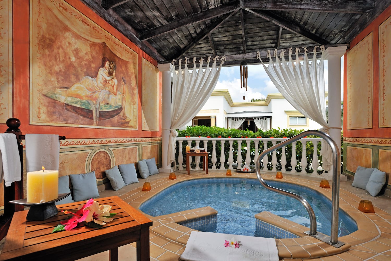 a hot tub with a table and chairs in a room with a painting on the wall