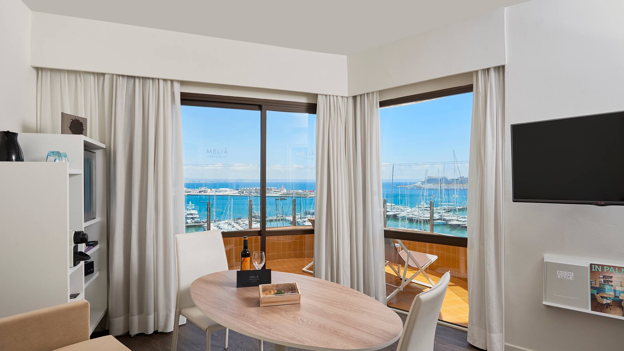 a room with a table and chairs and a television