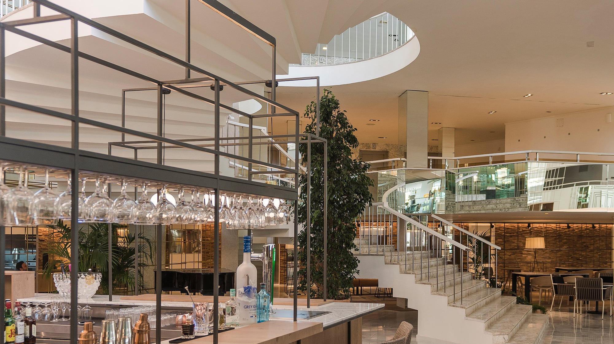 a bar with wine glasses and a staircase