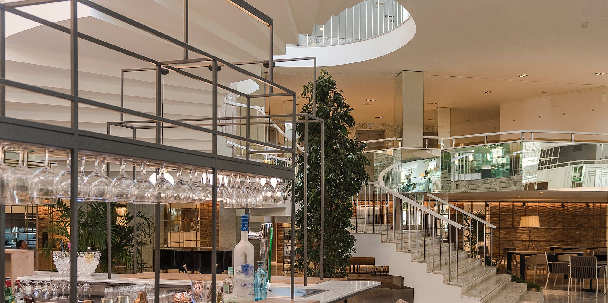 a bar with wine glasses and a staircase