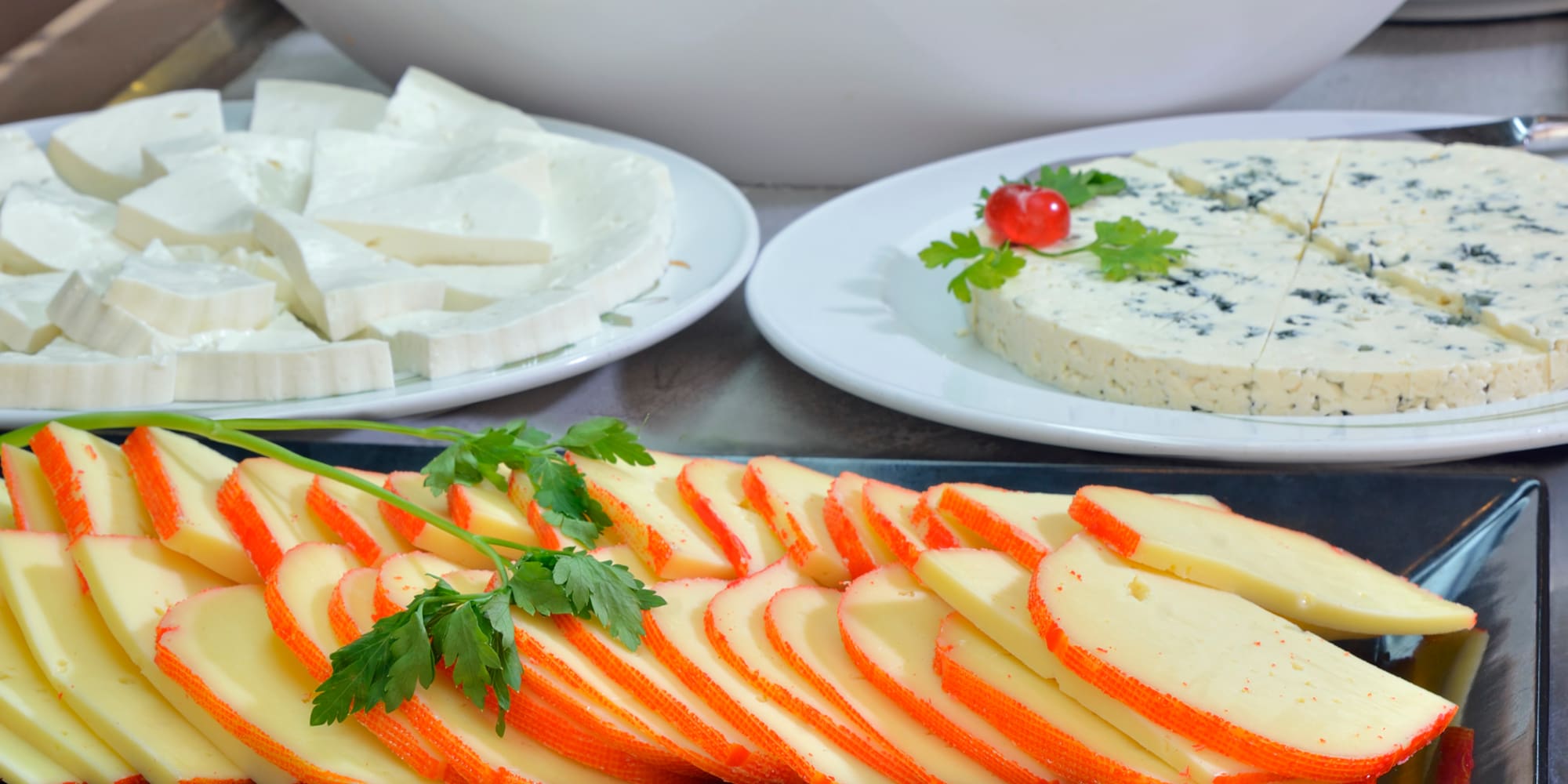 a table with plates of cheese and fruit