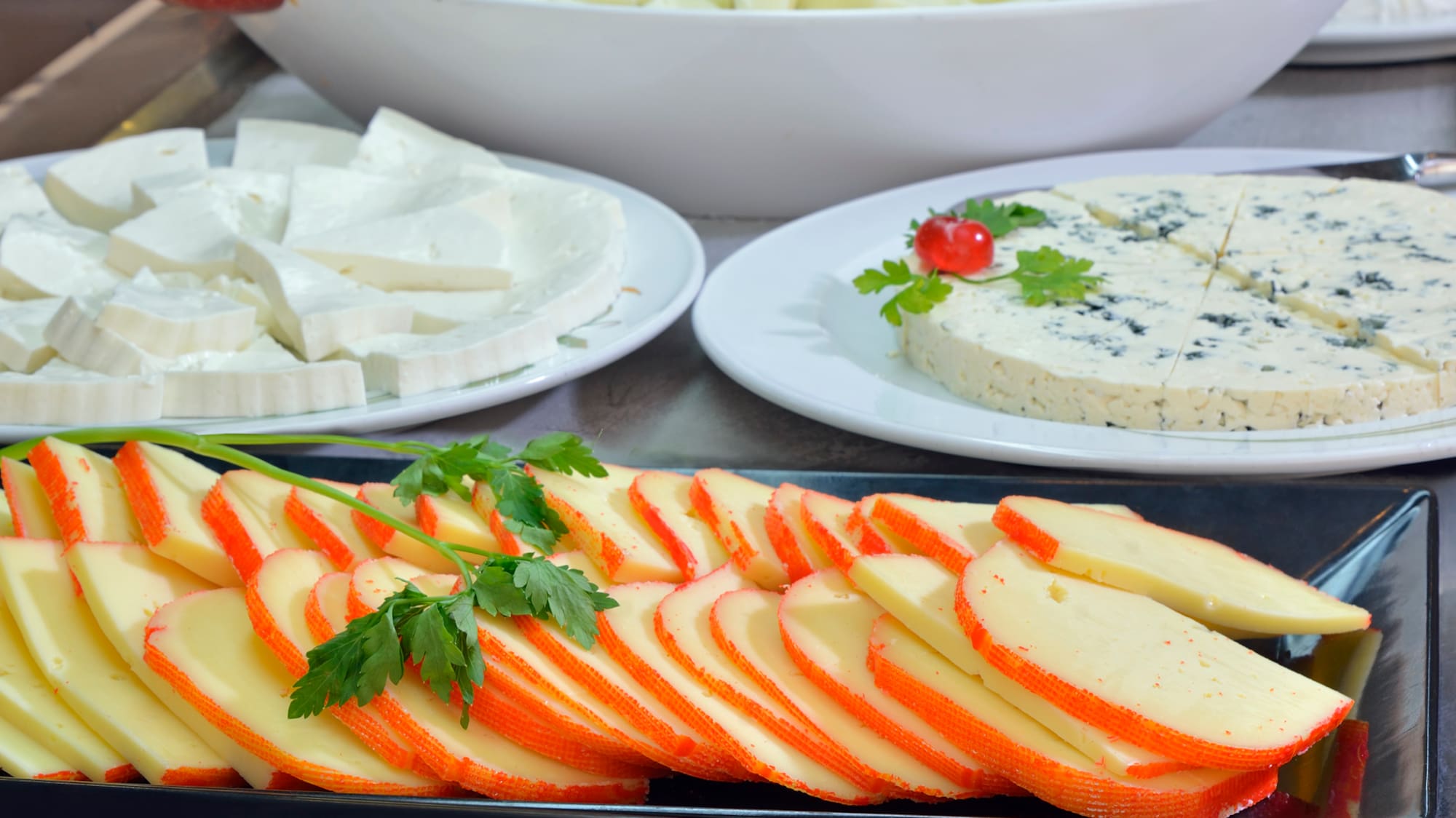 a table with plates of cheese and fruit