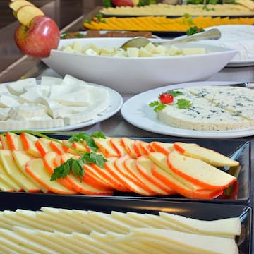 a table with plates of cheese and fruit