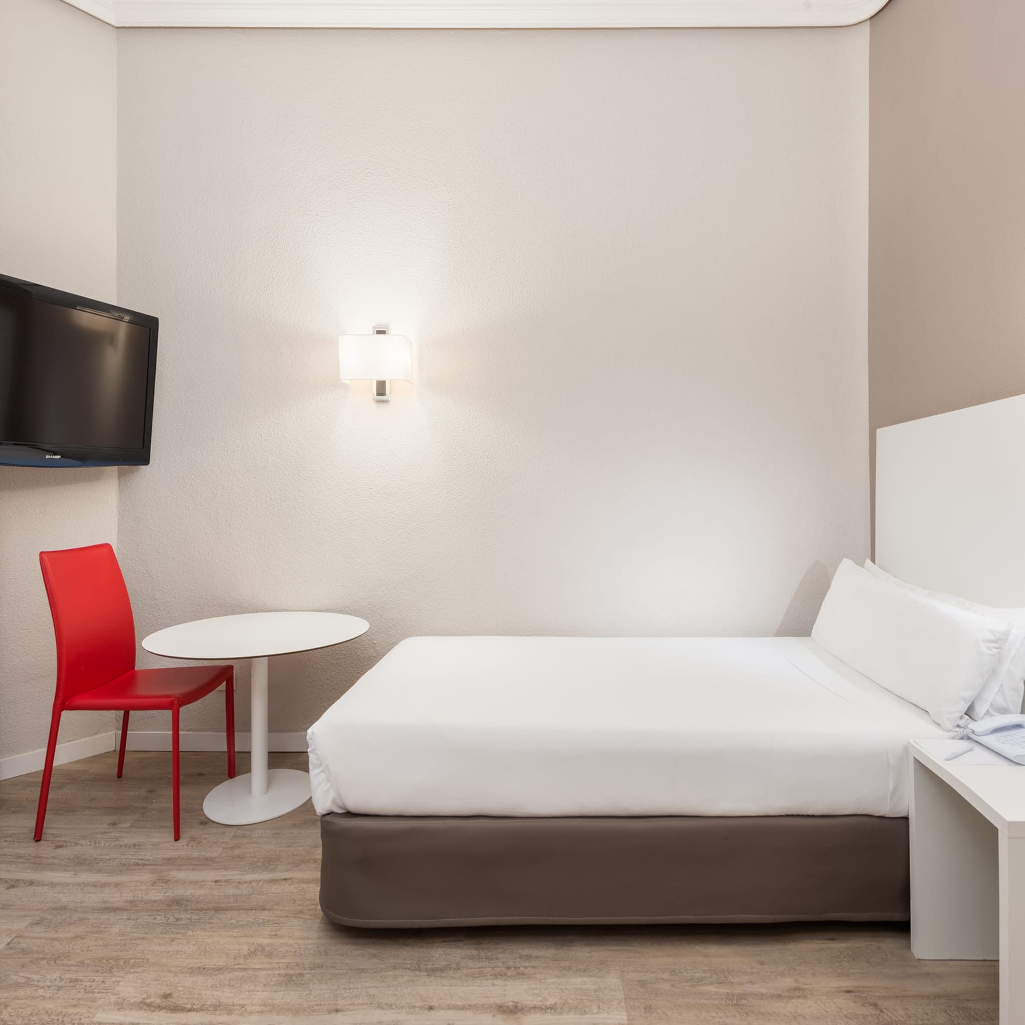 a room with a bed and a table and a tv