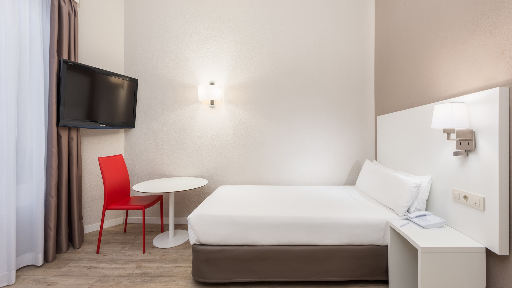 a room with a bed and a table and a tv