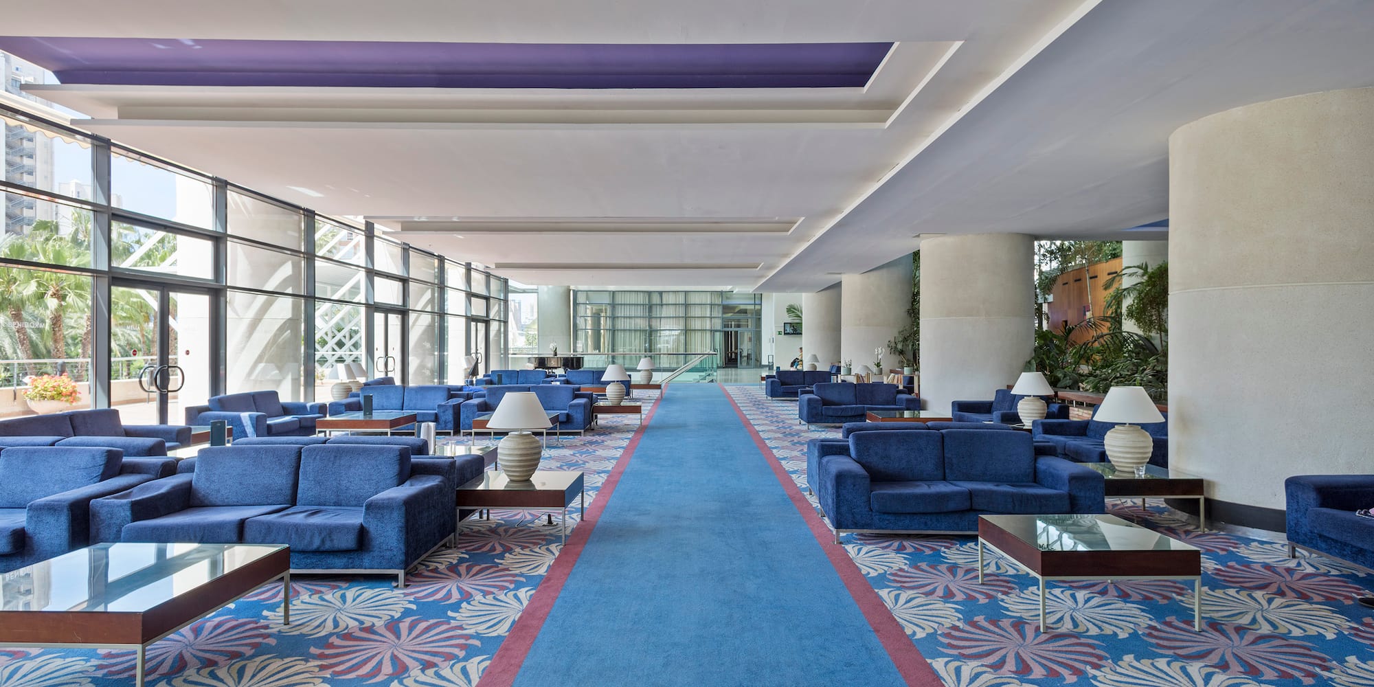 a blue couches and tables in a large room