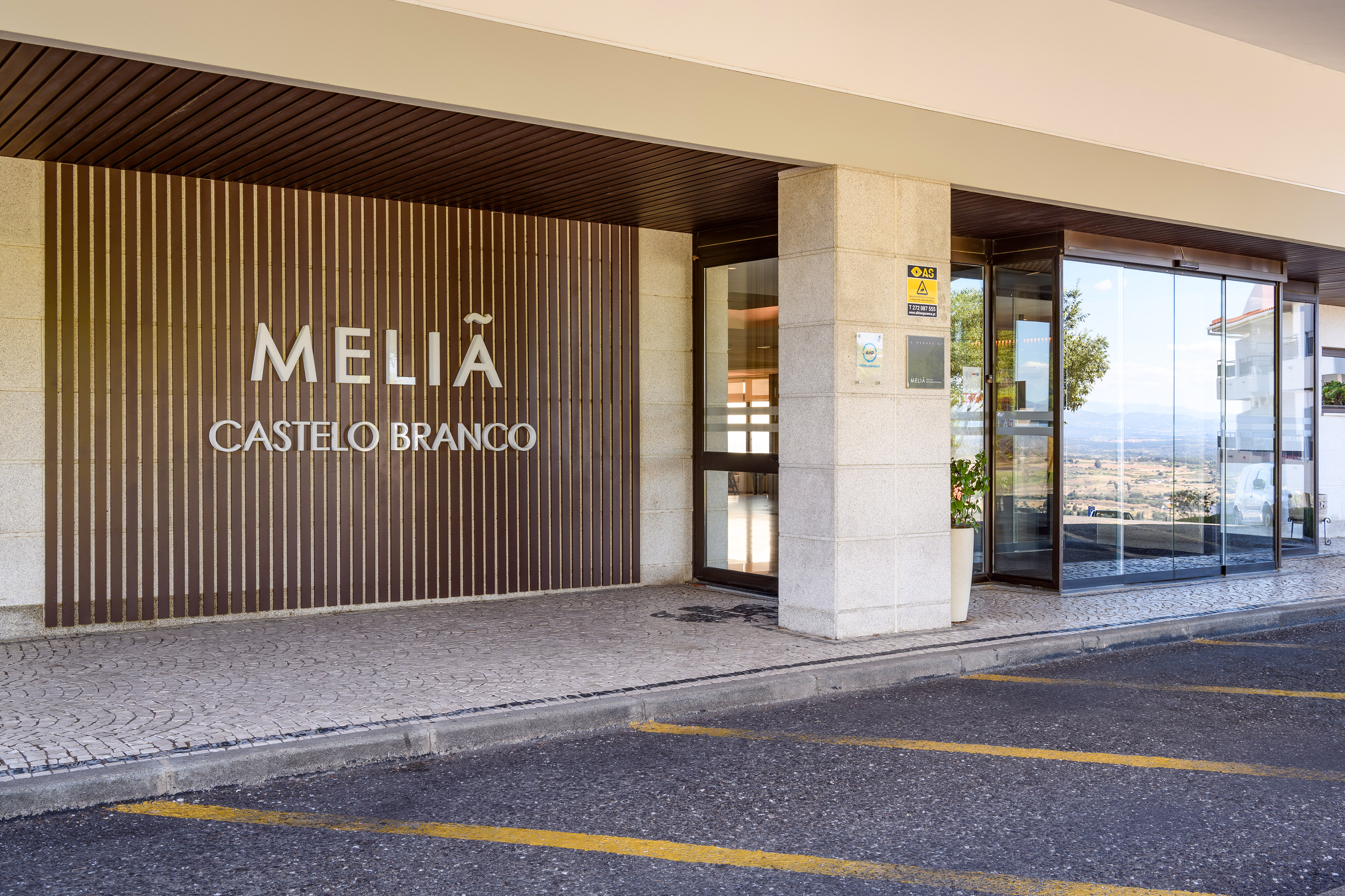 Meliã Castelo Branco hotel entrance with signage, glass doors, and paved drop-off area.