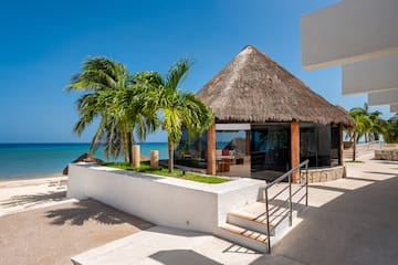 a building with a thatched roof and palm trees