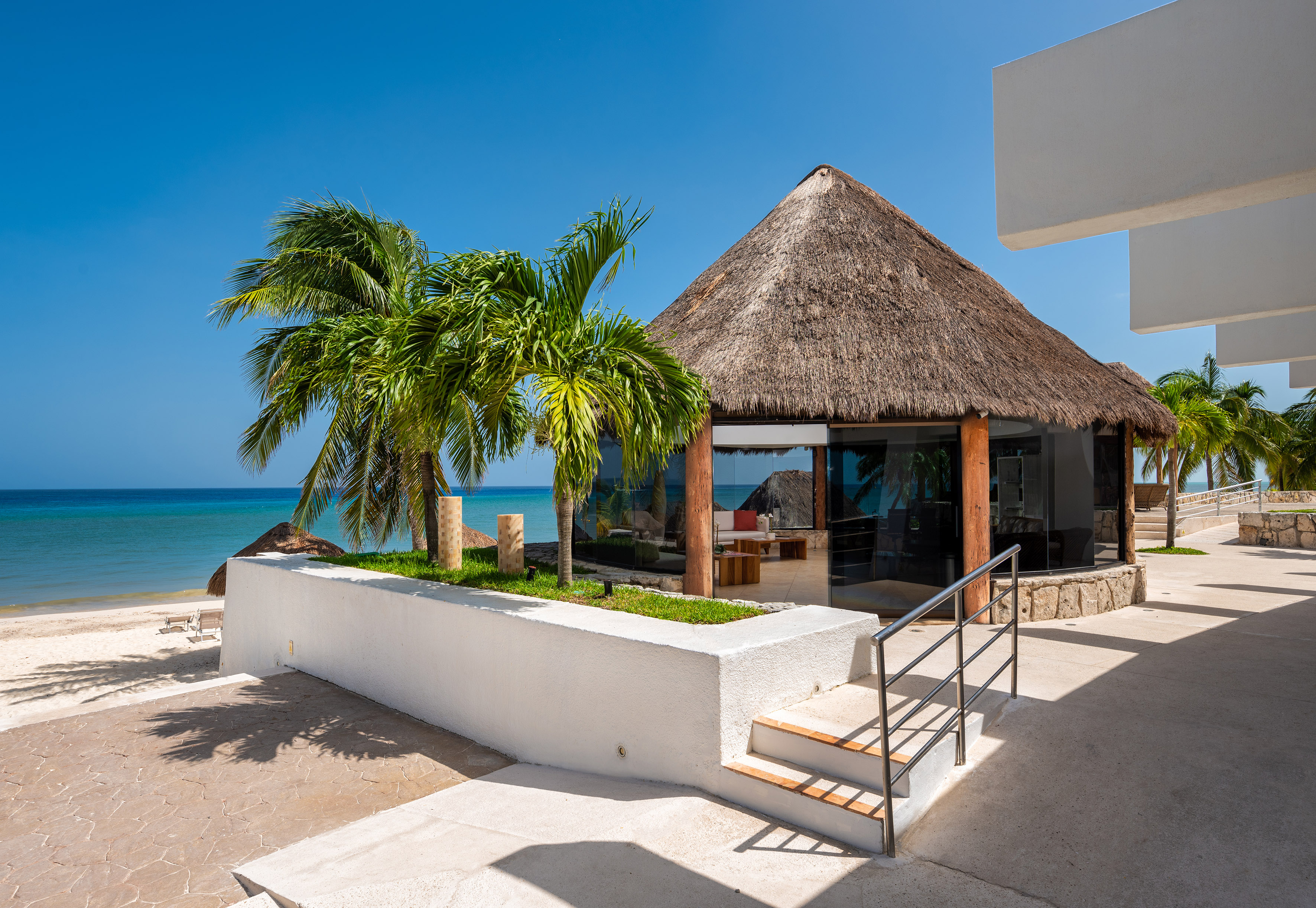 a building with a thatched roof and palm trees